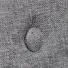 A close-up view of a tufted button on a gray fabric surface. Podgląd zdjęcia produktu