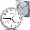 A white wall clock with a thermometer and hygrometer is shown in the foreground, with another identical clock in its packaging in the background. Produktbild-Vorschau