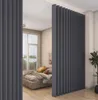 A bedroom with a bed and a large, dark gray vertical blind acting as a room divider. Náhled obrázku produktu