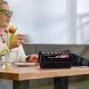 An older woman is sitting at a table, holding a cup of coffee, with a wallet and a tulip on the table. Podgląd zdjęcia produktu