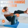 A woman is performing an exercise on a blue balance pad. Podgląd zdjęcia produktu