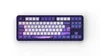 A top-down view of a dark purple mechanical keyboard with white and purple keycaps, set against a white background. Produktbild-Vorschau