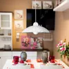 A dining table set with vases, glasses, and strawberries, with a pendant light hanging above. The background shows kitchen cabinets and artwork. Náhľad obrázku produktu