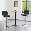 Two black bar stools and a small round table with drinks are shown in a room with a window. Produktbild-Vorschau