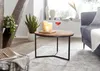 Runder Couchtisch mit Akazienholzplatte und schwarzem Metallgestell in Gesamtansicht im Wohnzimmer. Voir les images du produit