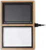 A top-down view of an electric grill with a black cooking surface and a white tray below, set within a bamboo frame. A power cord is visible on the right side. Produktbild-Vorschau