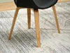 Close-up of the wooden legs of a black chair on a patterned rug. Voir les images du produit