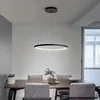 A modern dining room with a table and chairs, illuminated by a circular pendant light. Anteprima dell’immagine prodotto