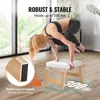 A woman is performing a yoga pose on a stool in a bright room with large windows. Voir les images du produit
