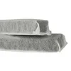 Two gray rectangular objects wrapped in white material, stacked one on top of the other, against a white background. Produktbild-Vorschau