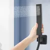 A hand holding a black shower head with water spraying out of it. Podgląd zdjęcia produktu