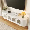 A white TV stand with glass doors and gold accents, placed in a living room setting with a TV above it. Podgląd zdjęcia produktu