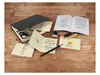 A calligraphy set laid out on a wooden surface, featuring a box, cards, envelopes, a pen, ink, and a guide. Produktbild-Vorschau