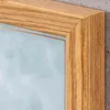 A close-up view of the corner of a wooden picture frame with a light blue background visible inside. Produktbild-Vorschau