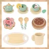 A collection of wooden toy tea set items arranged on a light brown and white striped background. Produktbild-Vorschau