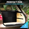 A folded black table is placed in the trunk of a car, suggesting it is being transported for travel. Produktbild-Vorschau