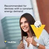 A woman wearing a watch, with a coin cell battery and Varta logo prominently displayed. Produktbild-Vorschau