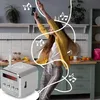 A woman is dancing in a kitchen while listening to music from a mini speaker. Produktbild-Vorschau