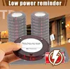 A hand holding a Retekess pager with a stack of pagers in the background, with a cafe or restaurant setting visible. Voir les images du produit