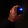 A hand holding a black device with a bright blue light emanating from it. Náhled obrázku produktu