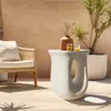 An outdoor patio scene with a chair, a side table, and a plant. Náhled obrázku produktu