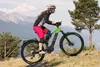 A woman riding an electric mountain bike on a rocky, mountainous trail. Produktbild-Vorschau