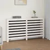 A white radiator cover with horizontal slats is shown in a room with a light-colored wall and wooden floor. Náhľad obrázku produktu