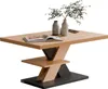 A modern coffee table with a unique geometric base and a wooden top, decorated with two vases and a book. Produktbild-Vorschau