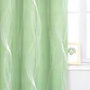 A close-up of a green curtain with a white wavy pattern, partially covering a window with a framed picture on the windowsill. Produktbild-Vorschau