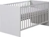 A white baby crib with a mattress inside, shown from a side angle against a white background. Produktbild-Vorschau
