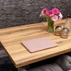 A pink notebook sleeve is placed on a wooden table next to a vase of flowers and two glasses. Produktbild-Vorschau