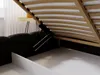 A close-up view of the underside of a bed frame, showing the wooden slats and a lifting mechanism. Produktbild-Vorschau