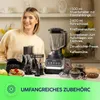 A woman stands behind a kitchen counter displaying a blender and its various accessories, with text listing the included items. Anteprima dell’immagine prodotto