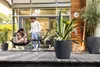 A couple relaxing on a wooden deck with plants and modern furniture. Podgląd zdjęcia produktu