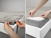 Two images showing hands tucking a fitted sheet onto a mattress. Anteprima dell’immagine prodotto