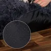 A close-up view of the bottom of a dark gray, plush dog bed, showing its anti-slip nubs on a wooden floor. Anteprima dell’immagine prodotto