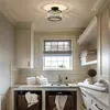 A well-lit laundry room with white subway tile walls, white cabinets, a sink, and a window with a bamboo blind. The ceiling light fixture is visible. Voir les images du produit