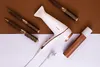 A white hairdryer with copper accents, along with several round brushes and a copper-colored spray can, are arranged on a brown and white background. Anteprima dell’immagine prodotto