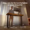 A man standing at a height-adjustable desk in a well-lit room. Produktbild-Vorschau