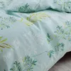 A close-up view of a light blue bed linen with a green and yellow leaf pattern. Produktbild-Vorschau