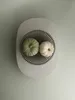 Two small pumpkins, one green and one white, are placed in a decorative metal bowl on a light gray oval tray. Produktbild-Vorschau