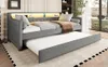 A gray daybed with a pull-out trundle bed is shown in a room with a window and some decor. Produktbild-Vorschau
