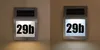 A solar-powered house number light with the number "29b" illuminated. Produktbild-Vorschau