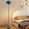 A bedroom scene with a floor lamp next to a bed. Podgląd zdjęcia produktu