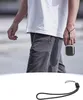 A person walking while holding a small square device with a lanyard attached to their wrist. Anteprima dell’immagine prodotto