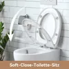 A toilet seat is shown in a bathroom setting with a soft-close feature being demonstrated. Náhled obrázku produktu