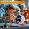A young boy is looking at a digital alarm clock with a colorful light display. Produktbild-Vorschau
