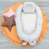 A baby nest with pillows on an orange mat. Produktbild-Vorschau