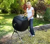 A woman is standing next to a black compost tumbler in a backyard setting. Náhled obrázku produktu