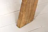 A close-up shot of a wooden table leg resting on a white wooden floor. Produktbild-Vorschau